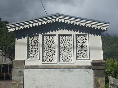 façade blanche d'une case à Hellbourg avec fenêtres et bord de toi décorés