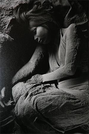 photo noir et blanc d'une femme accroupie un peu dans l'ombre