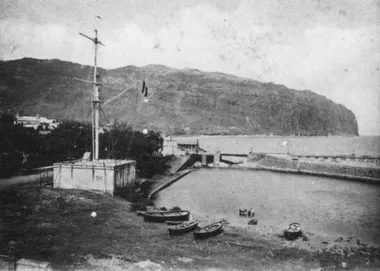 photo noir et blanc d'une petite lagune avec des barques avec un mât de signauxsur le coté gauche