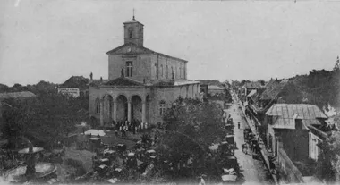 photo noir et blanc d'un plan large sur cette église avec beaucoup de fidèles sur le parvis et alentour