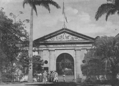 photo noir et blanc d'une façade neoclassique fermée d'une grille