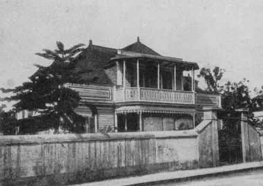 photo noir et blanc d'une villa créole avec varangue vue de l'autre coté de la rue