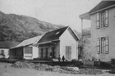 photo noir et blanc d'un allignement de petites maisons au pied d'une montagne