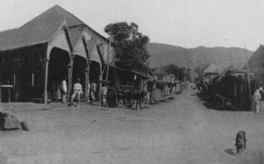 photo noir et blanc d'une rue avec une halle et des charettes