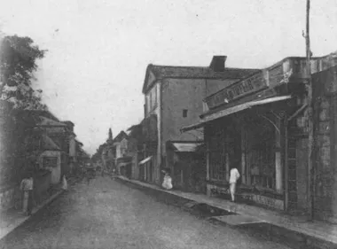 photo noir et blanc d'une rue bordée de maisons avec des passants