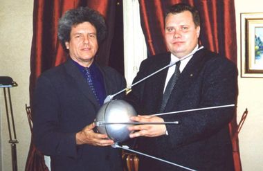 Guy Pignolet et Viktor Kurilov, porteurs du projet, portant une maquette du sputnik-1 dans leurs mains